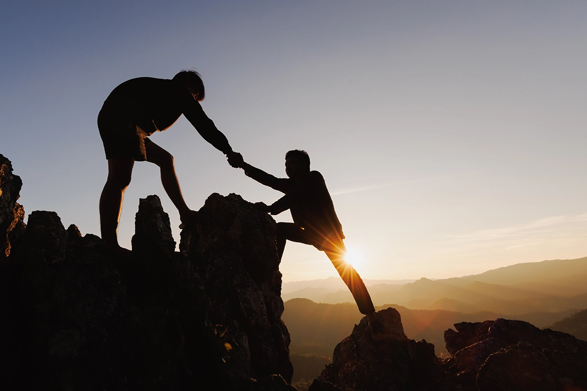 Strategic Partnerships – Empowering Success Together Silhouette_of_men_climbing_mountain_Managed_Services_Australia