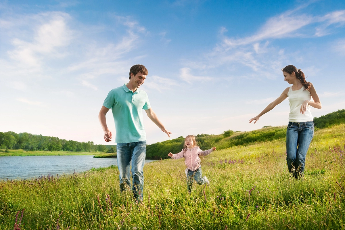 Family enjoying a run in a field of grass, representing the importance of e-waste management for future generations